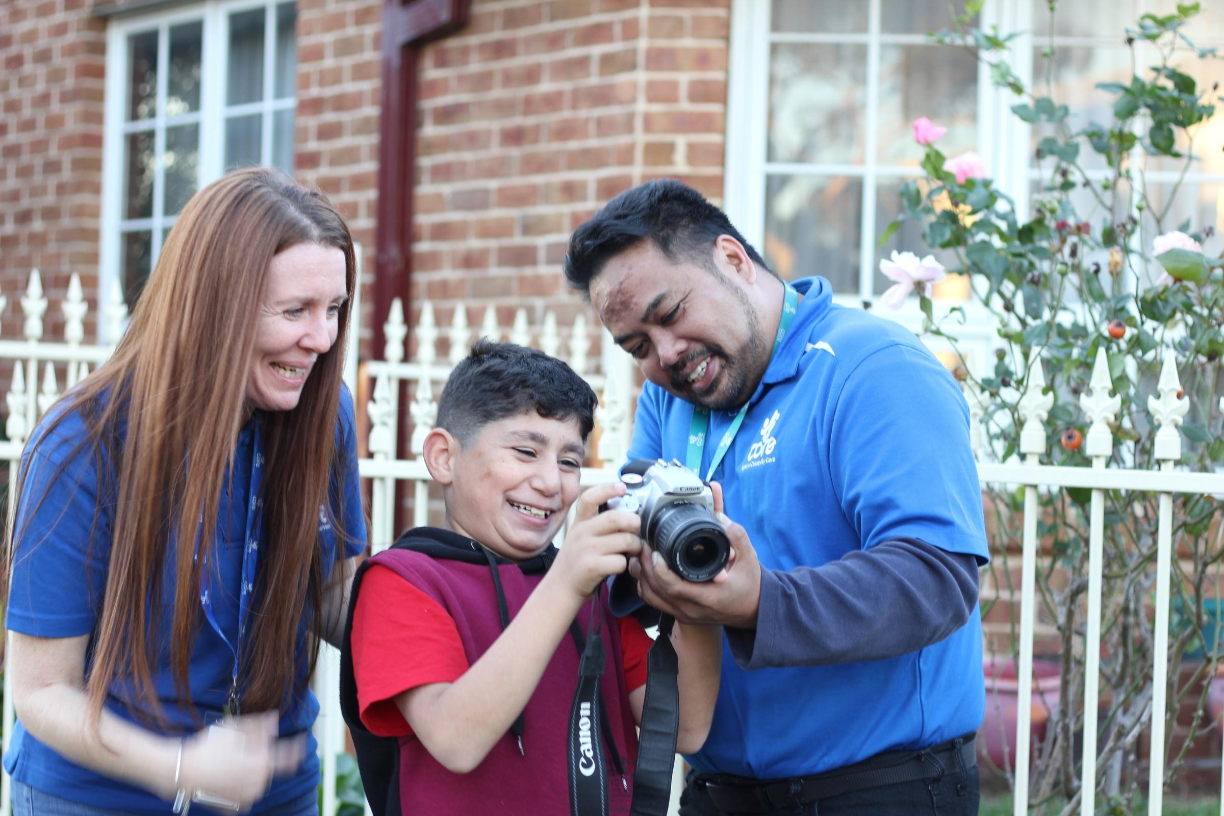 core workers smiling with young boy holding camera